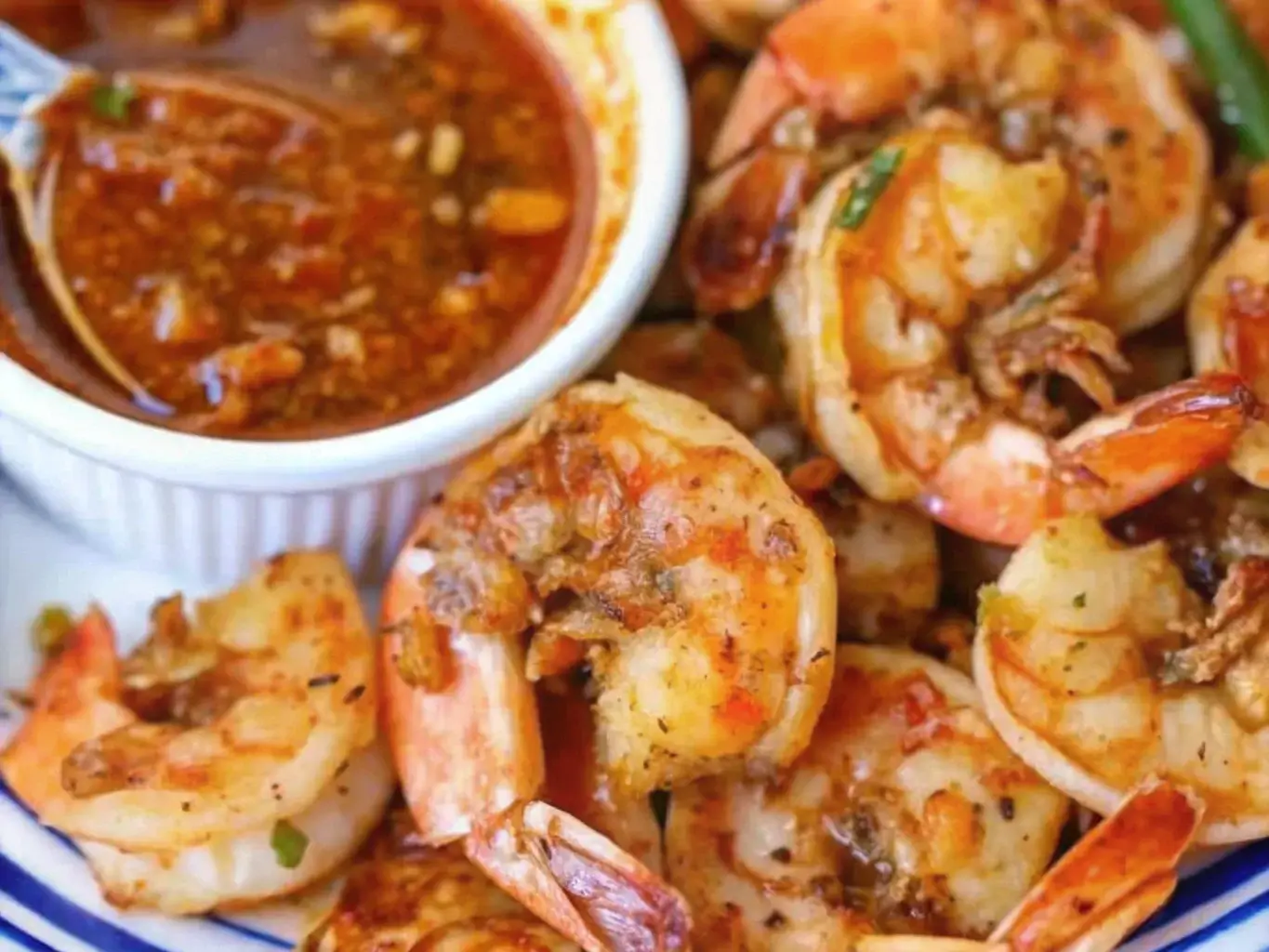 Seafood boil platter with sauce drizzled over shrimp and crab legs