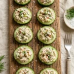Spicy tuna cucumber bites served on a wooden platter
