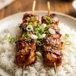 Delicious teriyaki chicken skewers served on a plate with vegetables.