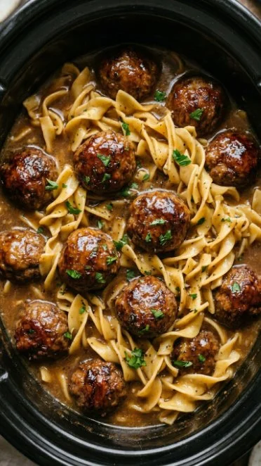 Amish meatball noodles cooked in a slow cooker, served in a bowl.