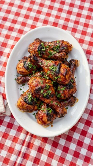 Baked BBQ Chicken Drumsticks garnished and ready to serve on a platter