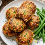 Delicious baked salmon patties served on a plate with fresh herbs.