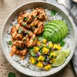 Charred shrimp avocado bowl garnished with fresh vegetables and lime