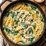 Bowl of creamy chicken lasagna soup garnished with herbs and cheese