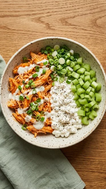 High protein buffalo chicken and cottage cheese bowl topped with fresh ingredients