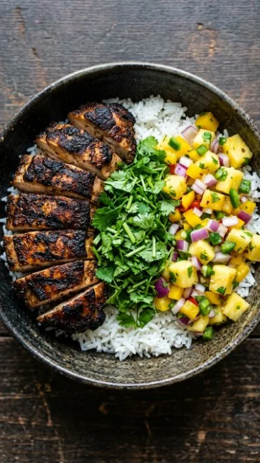 Delicious jerk chicken bowl with vibrant vegetables and rice
