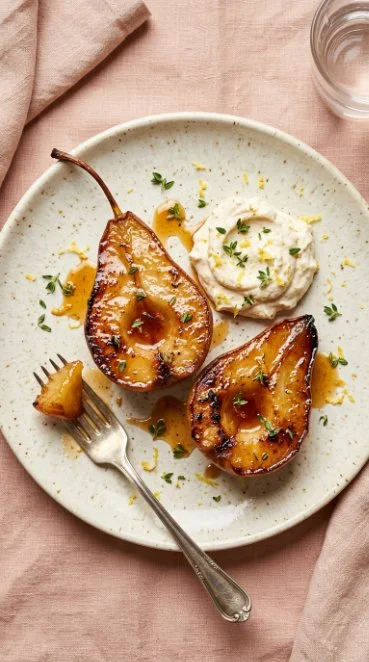 Honey caramel roasted pears served on a plate with drizzled sauce